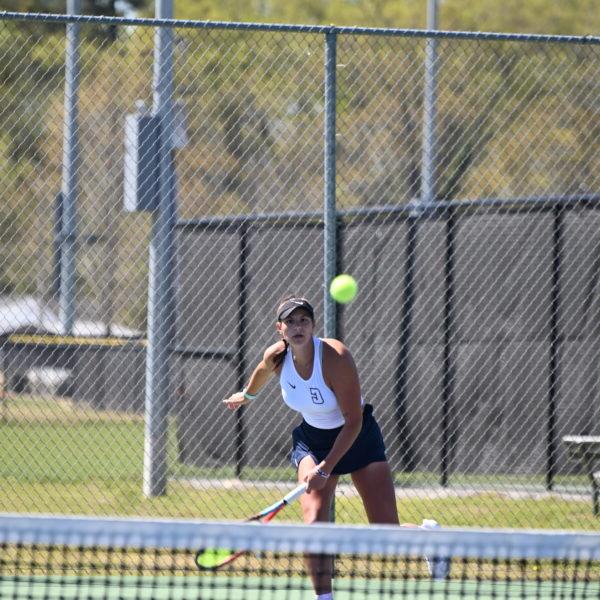 A Coker tennis player serves the ball.